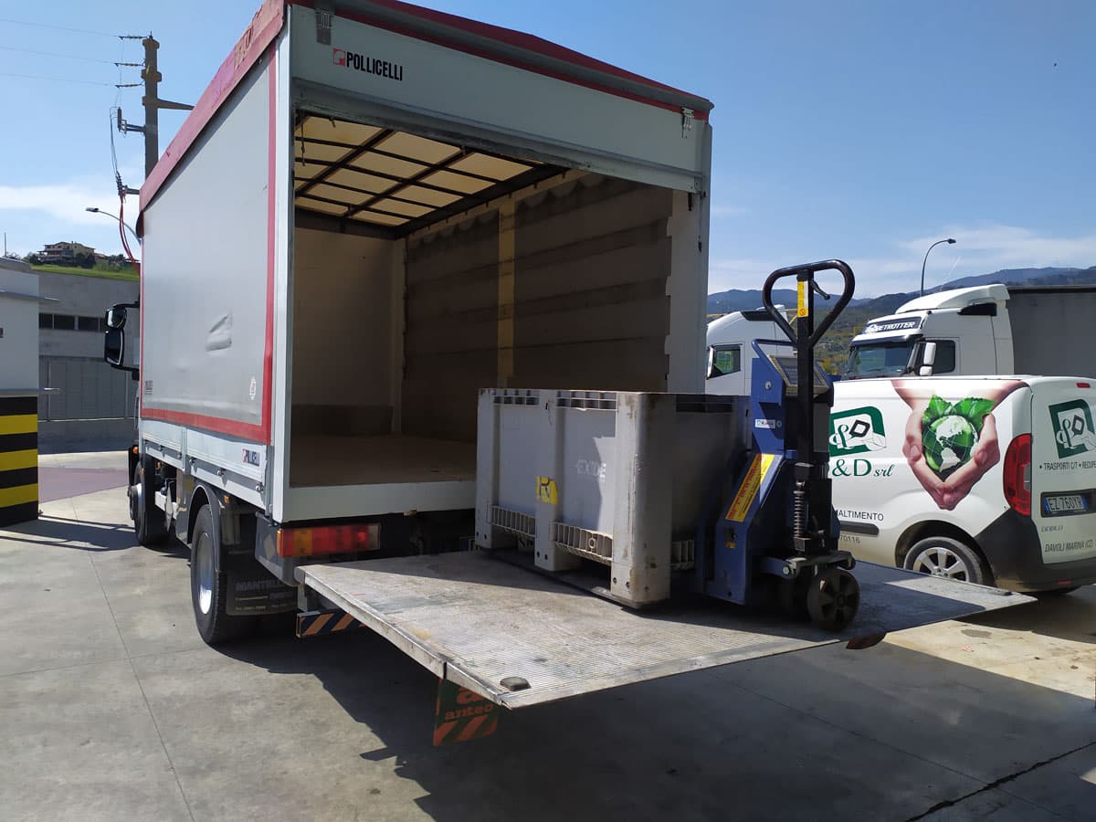 Autocarro D&D con sponda idraulica durante il carico e lo scarico